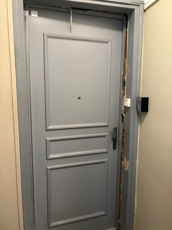 Porte d'appartement avec bâti endommagé après effraction